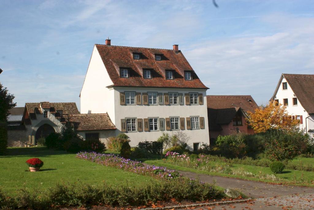 赖兴瑙Ferienwohnungen Haus Fuchs的一座大型白色房屋,设有红色屋顶