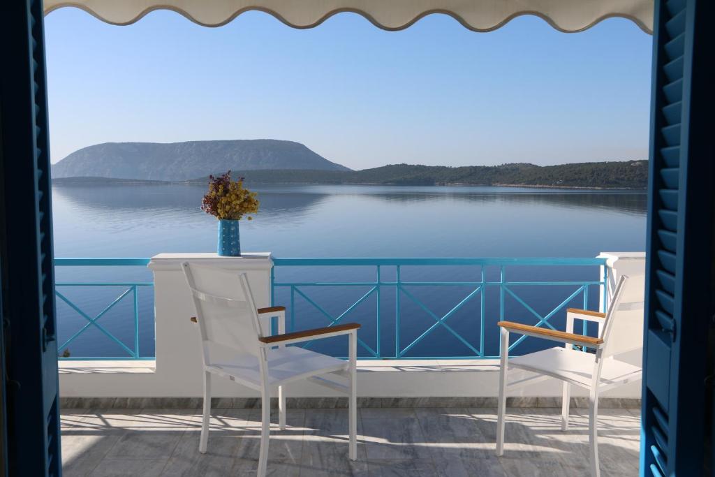 埃尔米奥尼Grand Bleu Apartments & Villas的阳台配有两把椅子,享有水景
