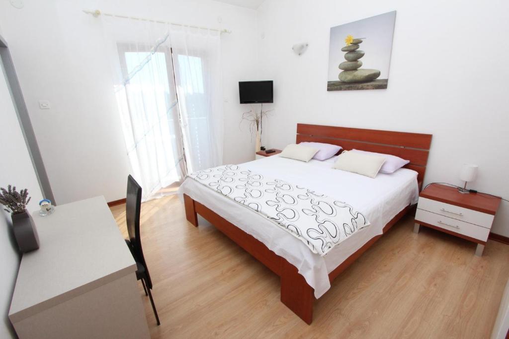 罗维尼Rooms and Apartment Luana的一间卧室配有一张大床、一张桌子和一张桌子