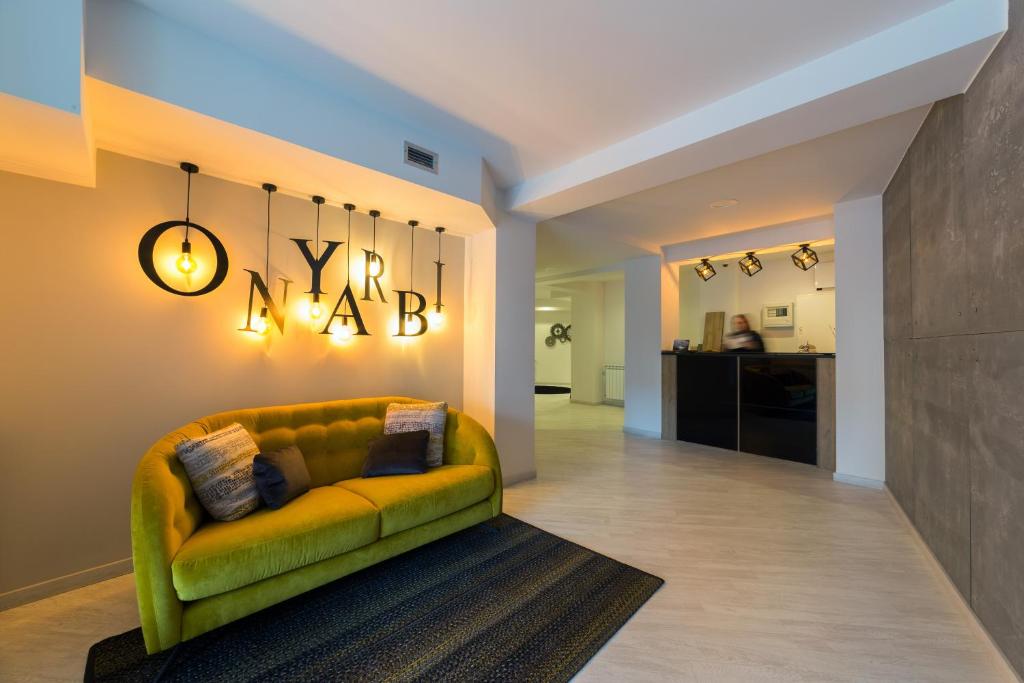 宏达瑞比亚Hotel Onyarbi的一间带绿色沙发的客厅和一间厨房