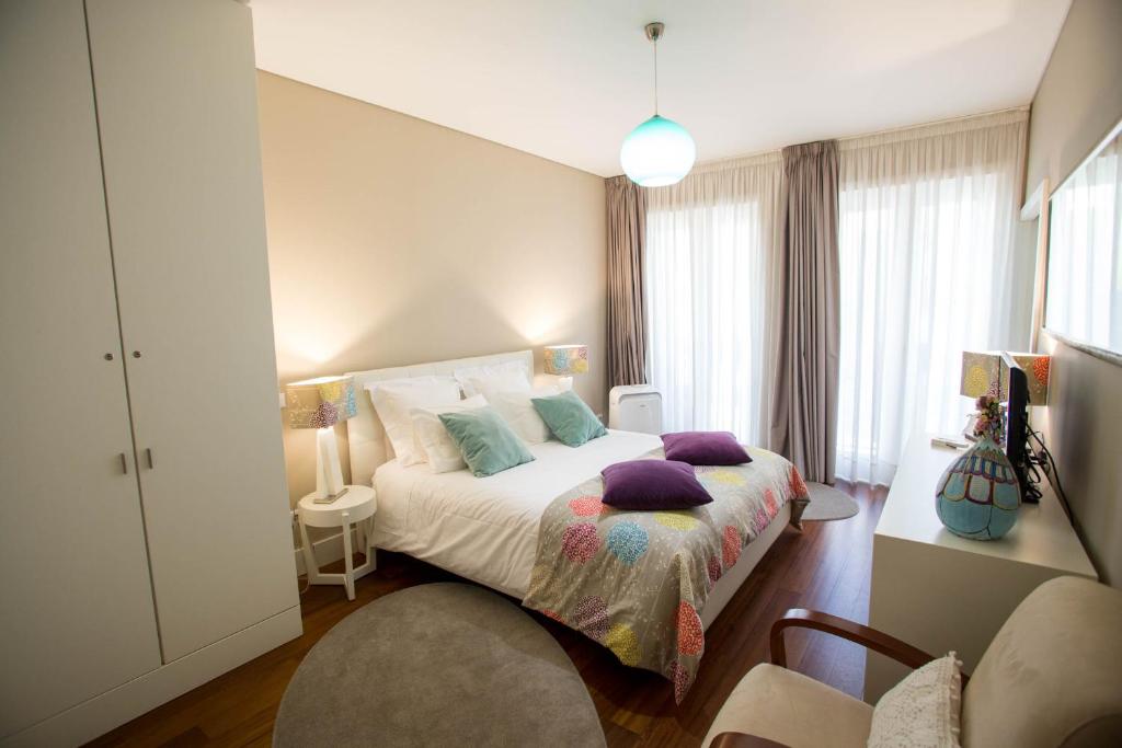 波尔图Cardosas Story Apartments by Porto City Hosts的一间卧室配有一张带紫色枕头的床