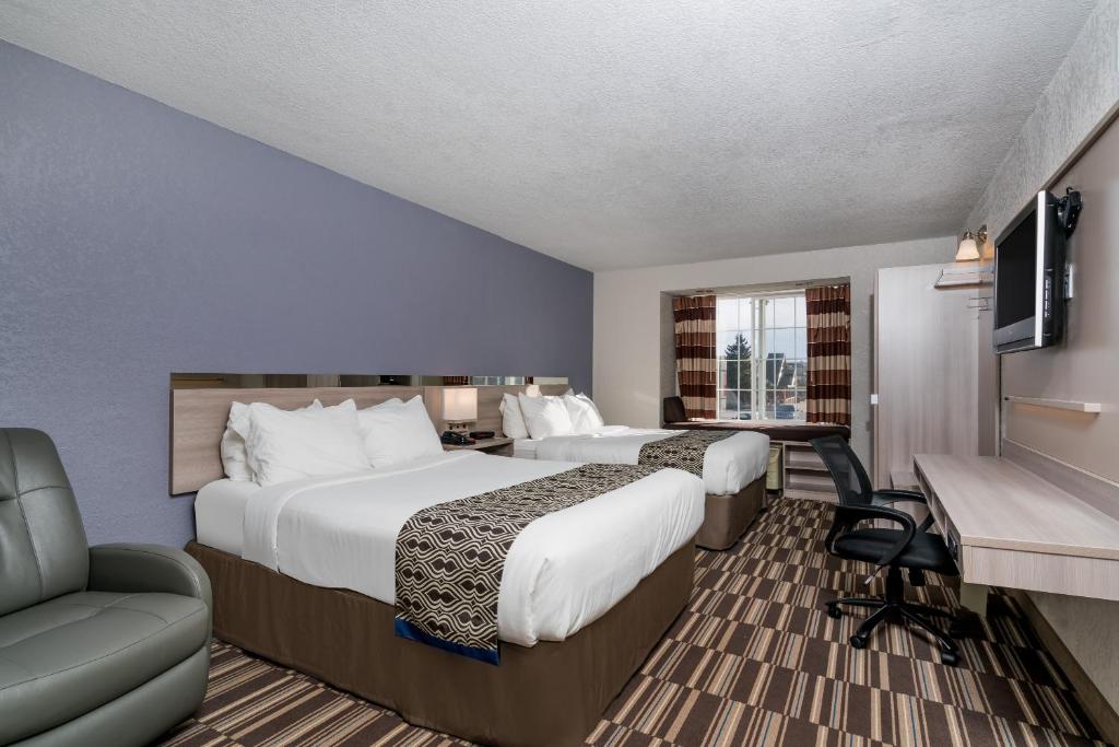 罗切斯特Microtel Inn & Suites by Wyndham Rochester North Mayo Clinic的酒店客房配有两张床和一张书桌