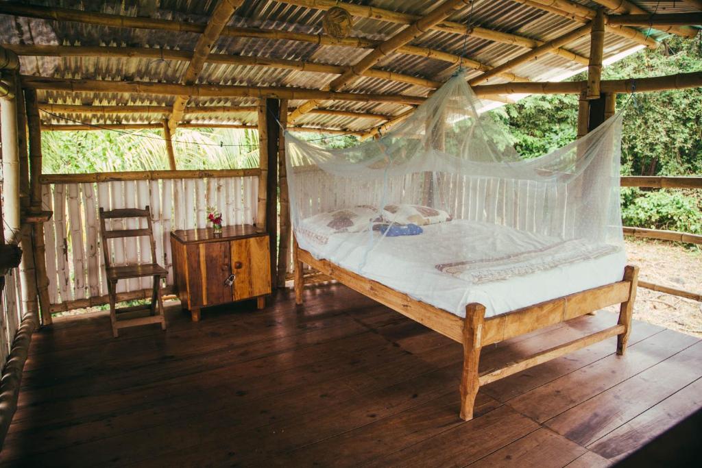 OmetepeFinca La Magia的一间卧室配有一张床,铺有木地板
