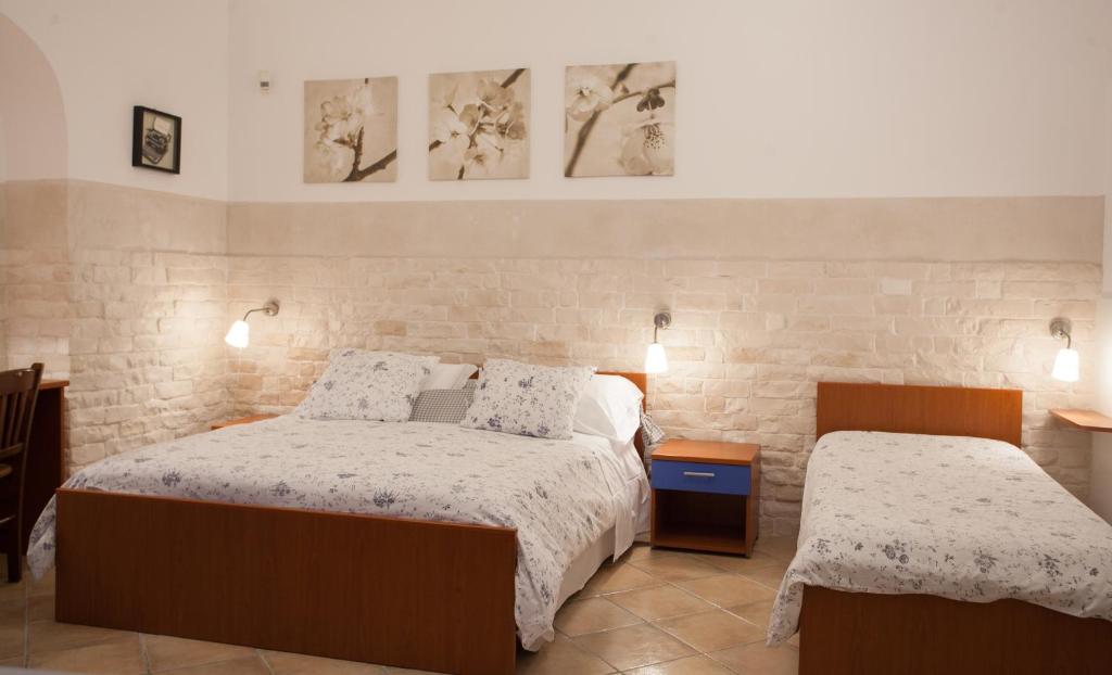 卡尔塔吉罗Trio D'Archi - La Maison de Cocò的卧室配有两张床,墙上挂有两张照片
