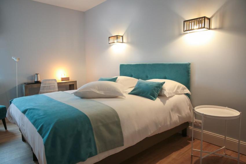 维姆勒Hotel Des Arts的一间卧室配有一张带蓝白色床单的大床
