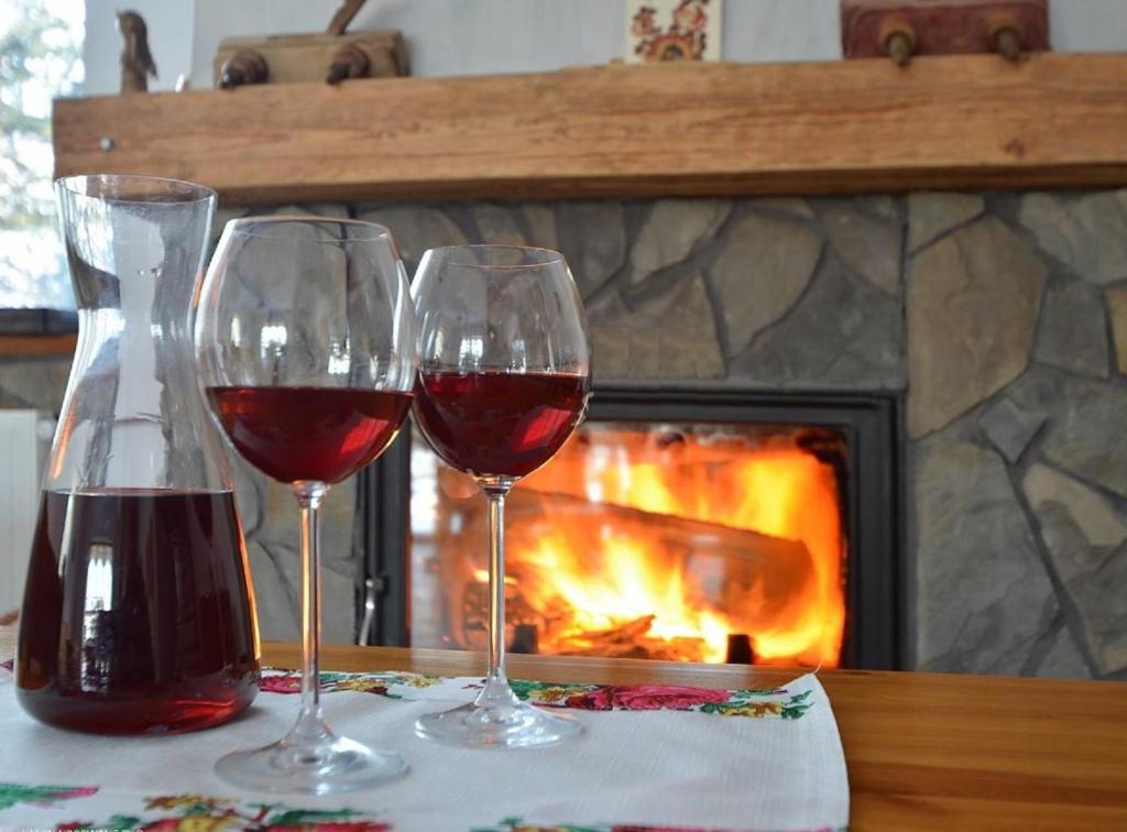 拉普斯尼恩Winnica Spisz的壁炉前的桌子上放着两杯葡萄酒