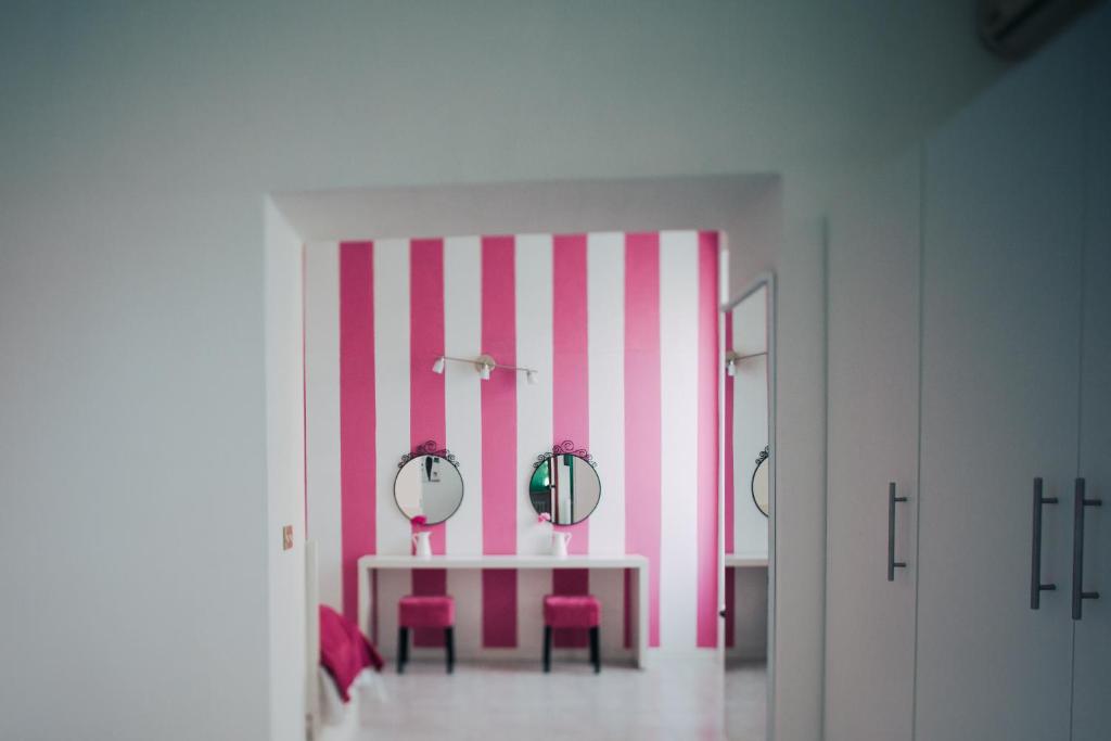 萨尔索马焦雷泰尔梅精英酒店的粉红色和白色的房间,配有一张桌子和两面镜子