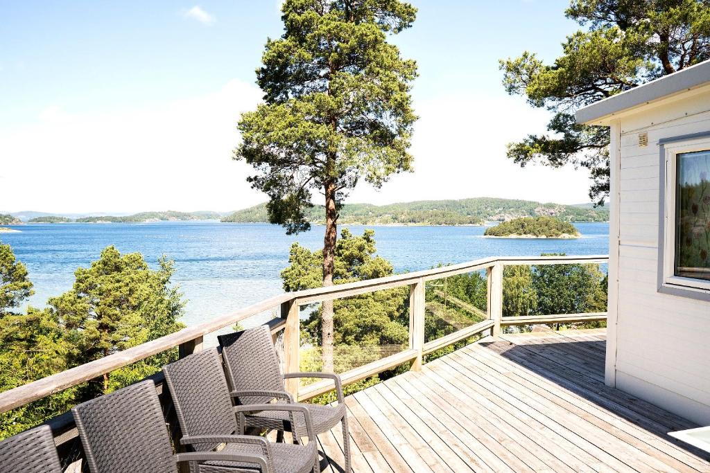 卢恩斯基尔Anfasteröd Gårdsvik - Örnnästet的一个带椅子的甲板,享有水景