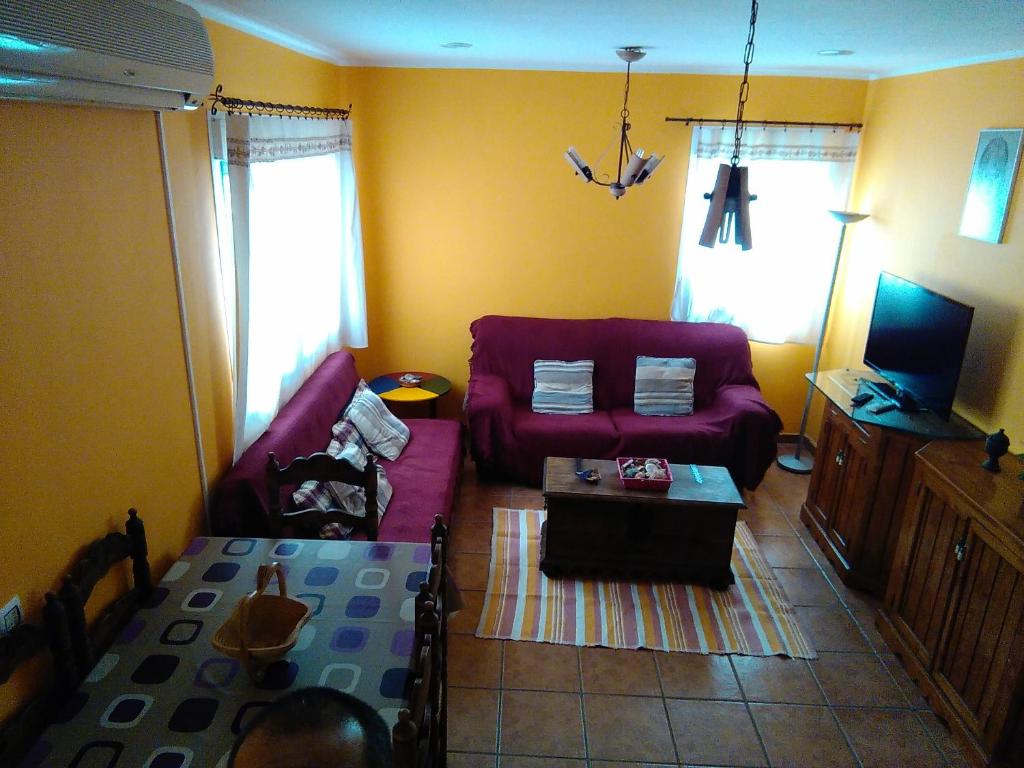 拉斯内格拉斯Bonito apartamento的客厅配有红色的沙发和桌子