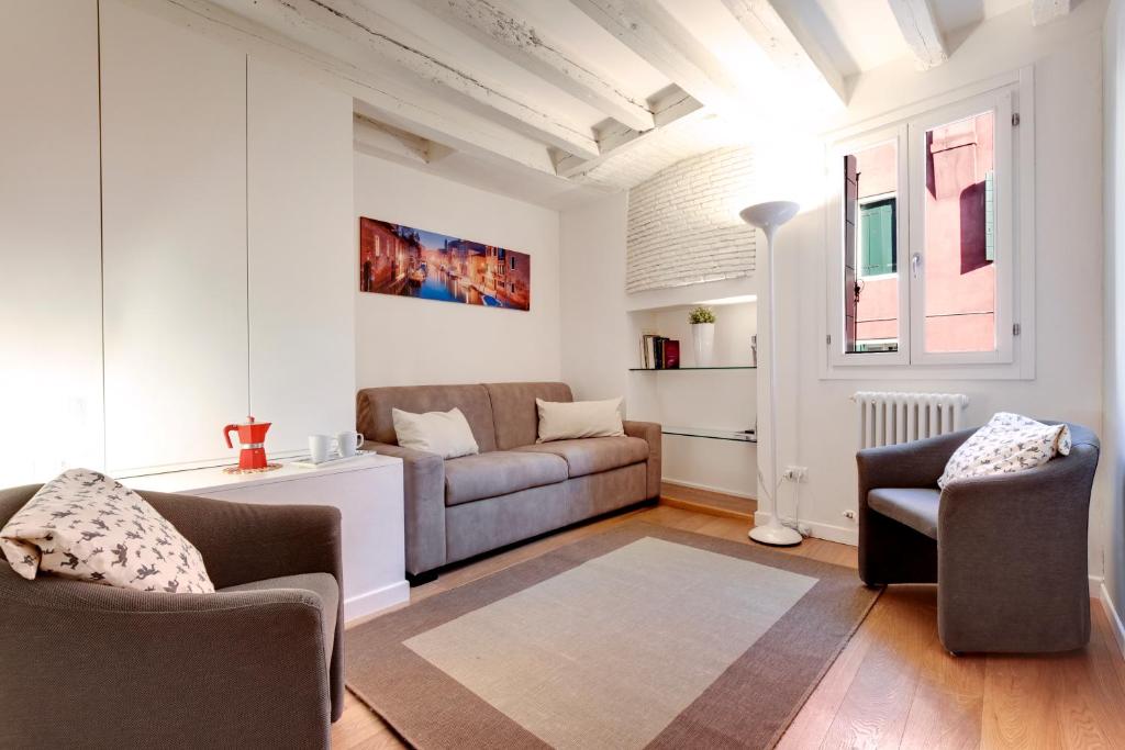 威尼斯San Marco Prestige - S. Zaccaria的客厅配有沙发和两把椅子