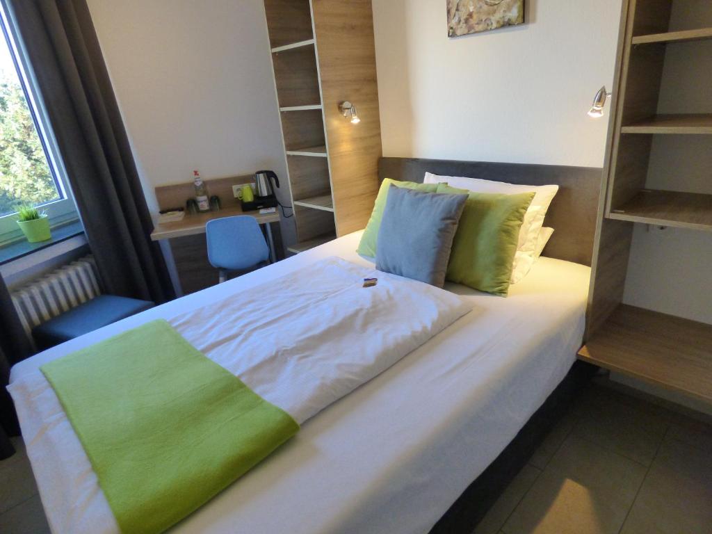 丁斯拉肯丁斯拉肯艺术酒店的一间卧室配有一张带绿色和白色床单的大床