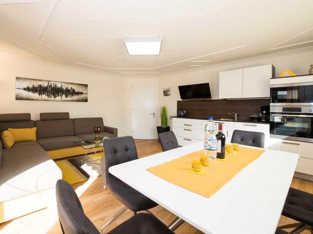万丹斯Ferienwohnung - Bergblick - Vandans的厨房以及带白色桌椅的起居室。