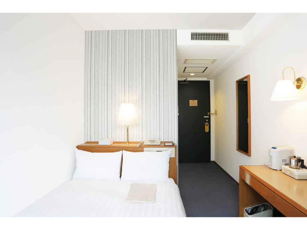 东京日本桥三越前微笑酒店的酒店客房配有一张床和一张带台灯的书桌