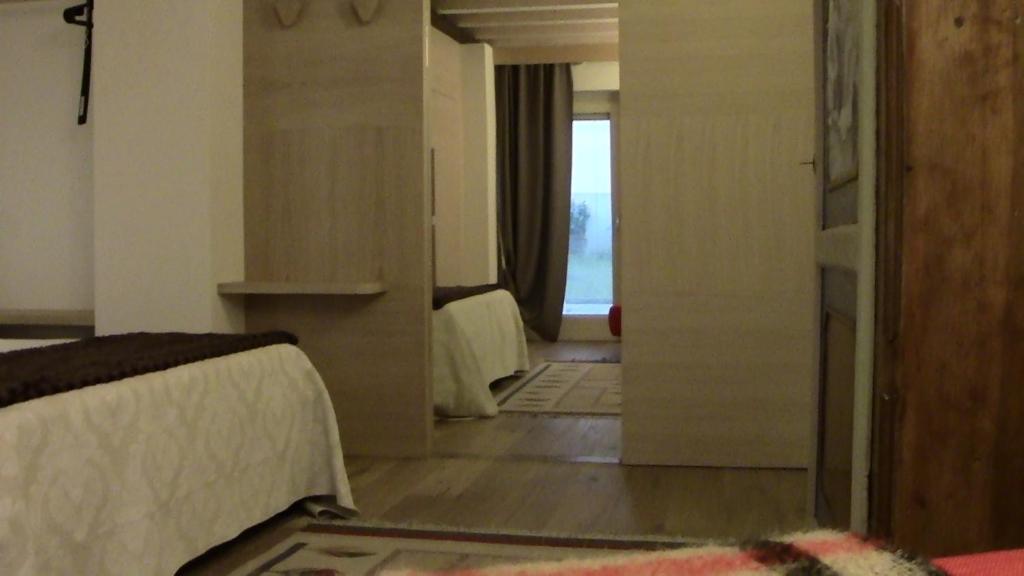 维罗纳Casa Bella的一间卧室设有两张床,一扇门通往房间