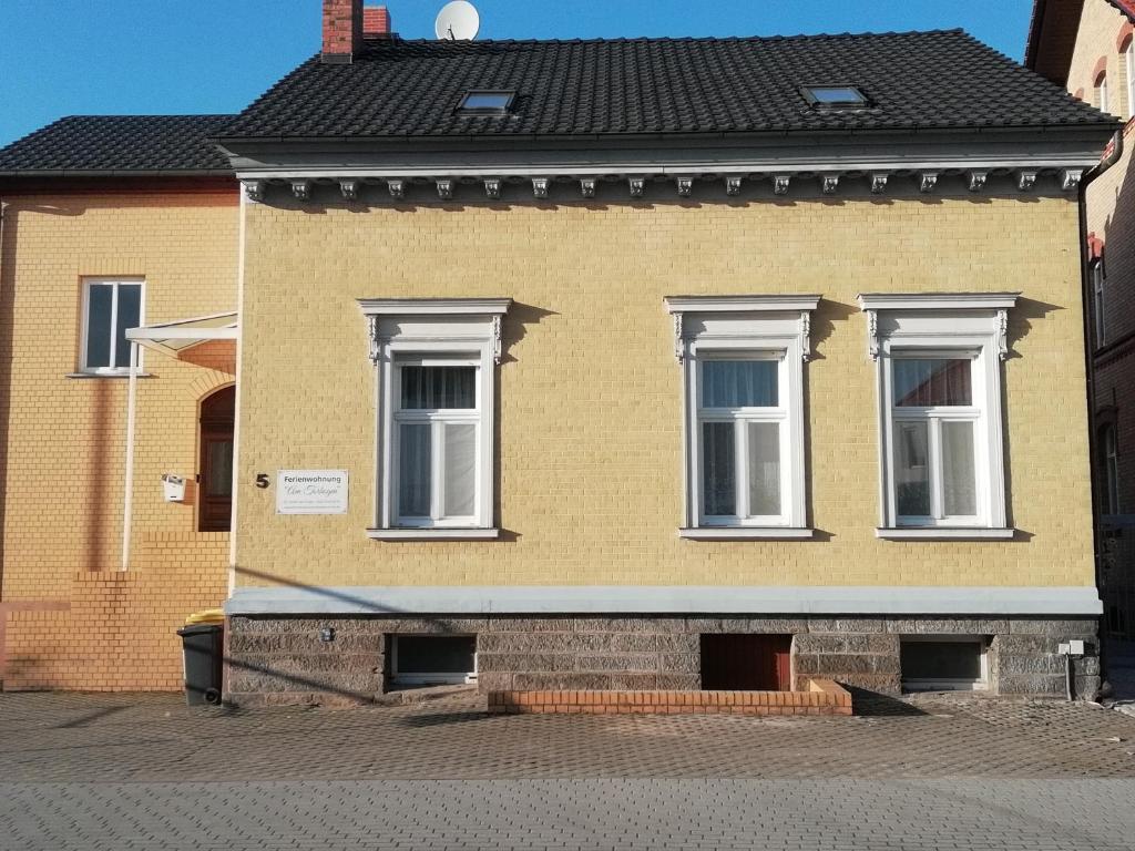 吕本瑙Ferienwohnung am Torbogen的街上的黄色房子,有白色窗户
