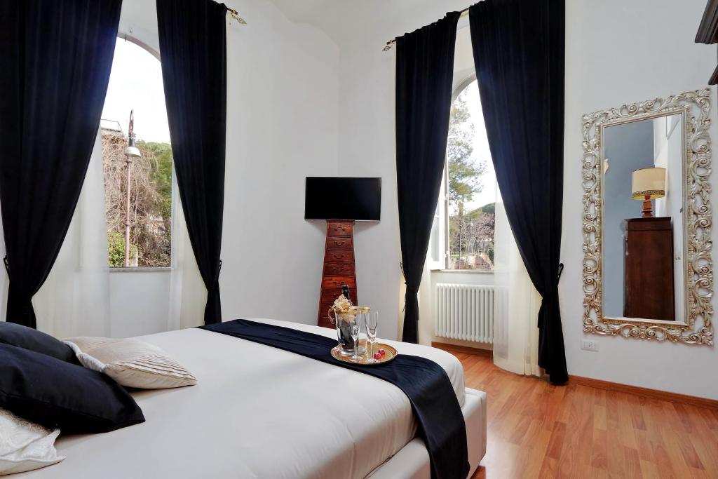 罗马斗兽场甜蜜公寓的一间卧室配有一张带黑色窗帘和镜子的床