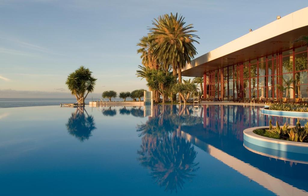 丰沙尔佩斯塔纳赌场公园酒店&赌场的一座拥有建筑和棕榈树的游泳池