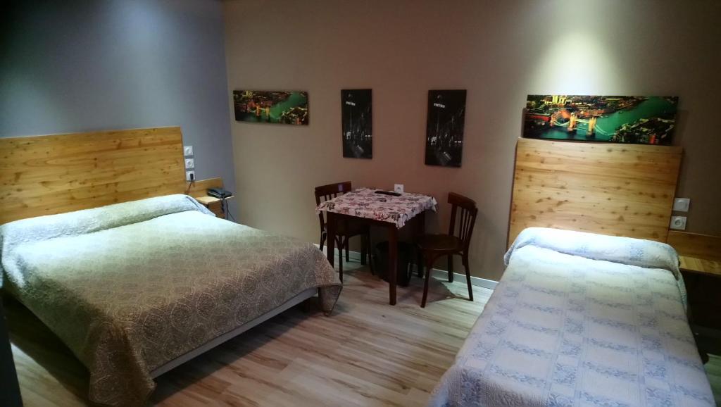 圣克洛德Hotel de la Poste的一间卧室配有两张床和一张桌子