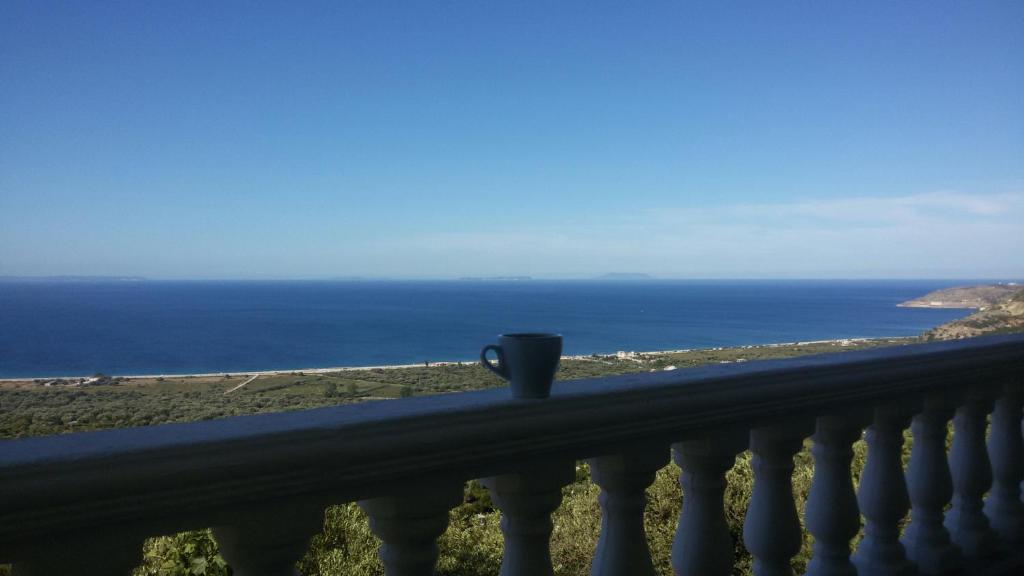 博尔什OniRana Apartments的咖啡杯坐在俯瞰大海的阳台上