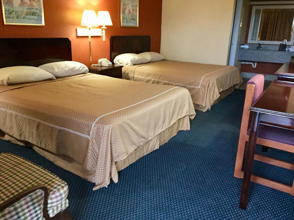 特克萨卡纳特克萨卡纳行政汽车旅馆的酒店客房设有两张床和一张桌子。