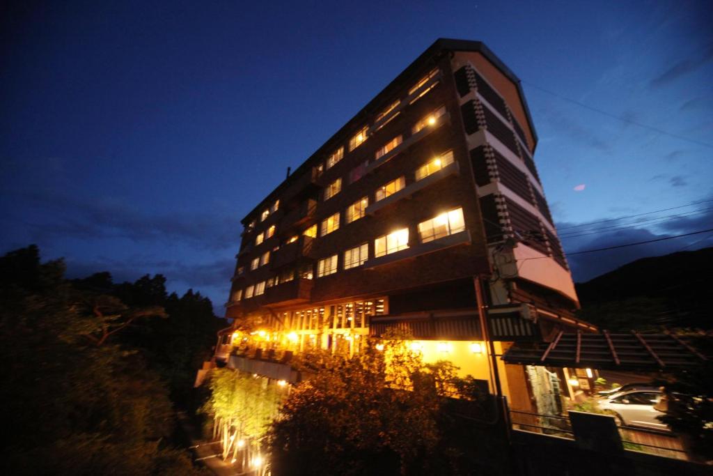 云仙市云仙福田酒店的一座高大的建筑,晚上有灯