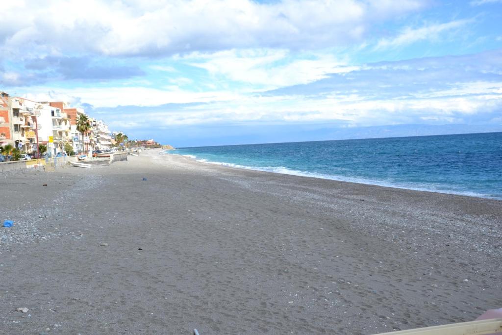 勒托阳尼Hotel Caudullo的一片空旷的海滩,有建筑和海洋