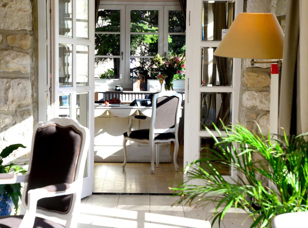 艾日Hôtel Eze Hermitage entre Nice et Monaco的庭院里配有桌椅的房间