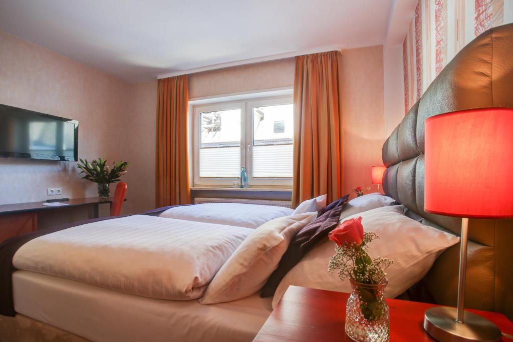 曼海姆莱茵内卡尔酒店的一间卧室设有一张大床和一个窗户。