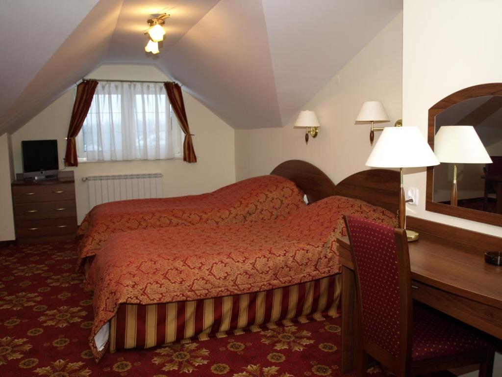 沃拉达卡热拉科斯酒店的一间卧室配有一张床、一张书桌和一面镜子