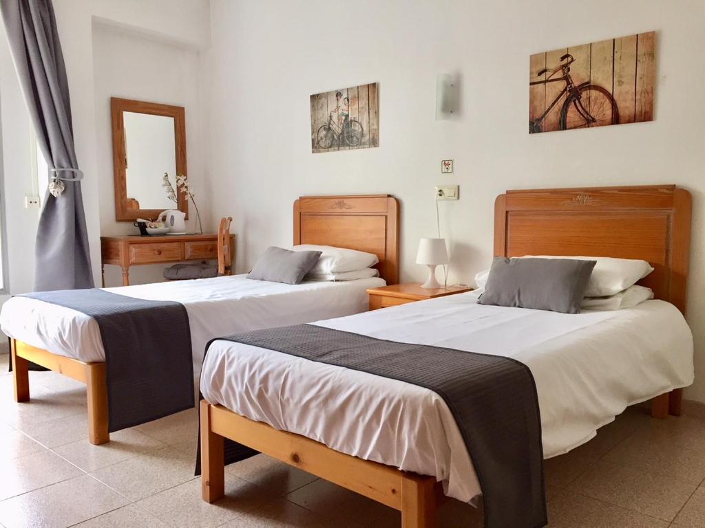 卡拉米洛Sol y Luna Cala Millor的配有两张桌子和镜子的客房内的两张床