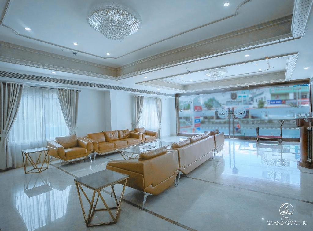 KhammamHotel Grand Gayathri的客厅配有沙发和桌子