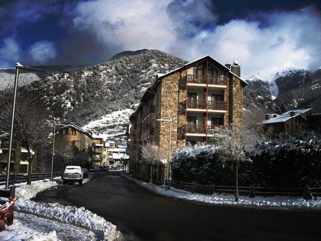 奥尔迪诺拉普朗达酒店的一座位于雪覆盖的山边的建筑