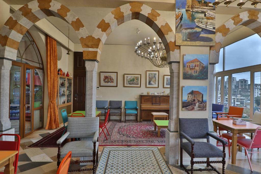 朱尼耶Damask Rose, Lebanese Guest House的大堂设有拱门和桌椅