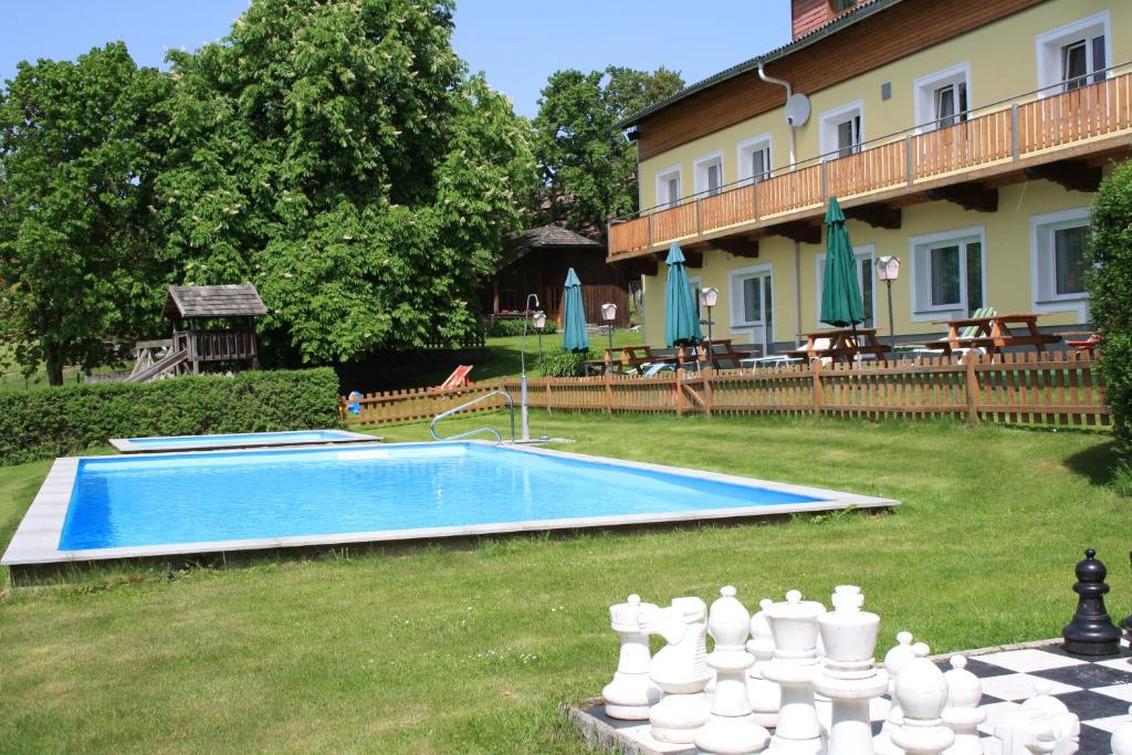 阔勒斯赫拉格拉姆霍夫运动膳食旅馆的院内的一个游泳池,旁边是棋盘