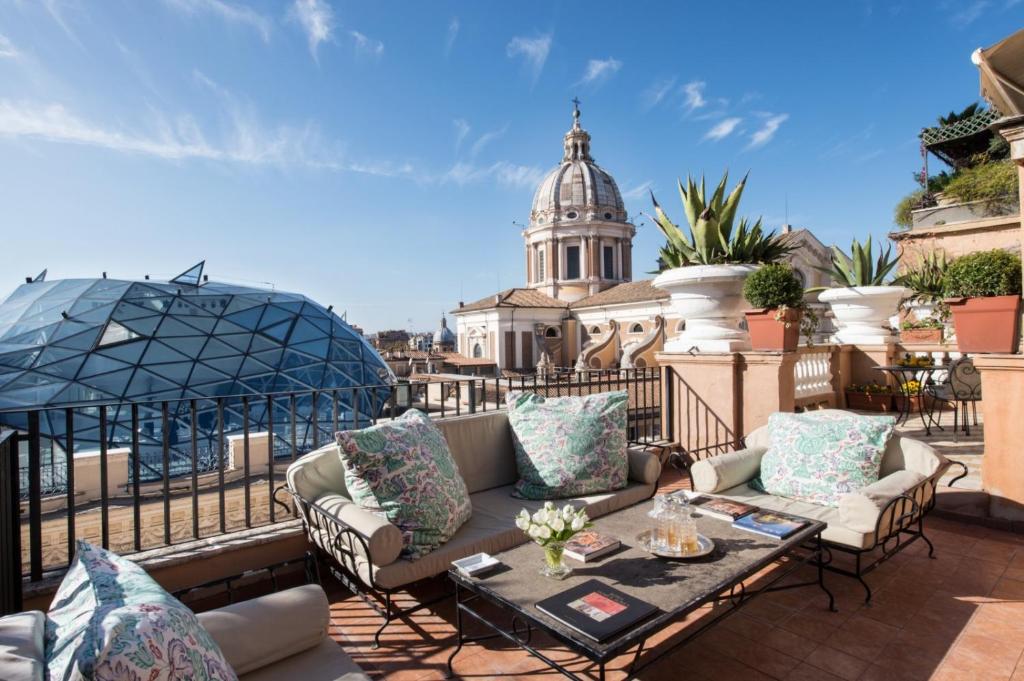 罗马广场大酒店的一个带沙发和桌子的屋顶庭院