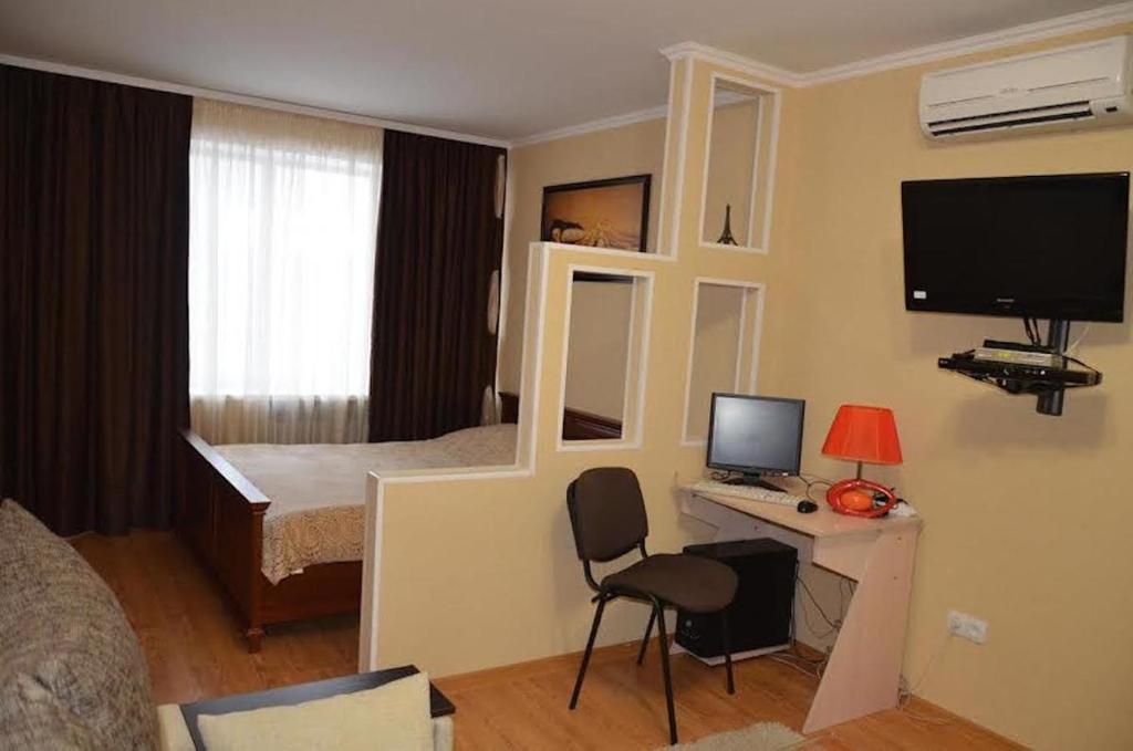 尼古拉耶夫Затишна квартира у самому центрі , на Соборній的一间卧室配有一张床和一张带电脑的书桌