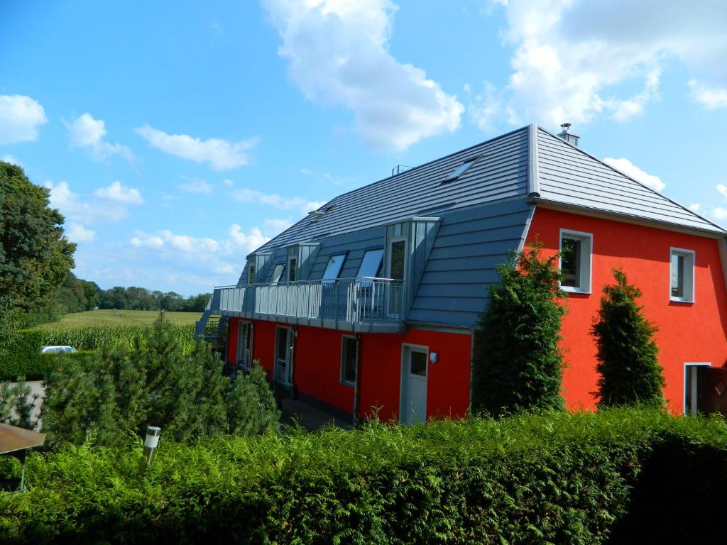 勒伯尔FEWOTRAUM-MÜRITZ的一座红色的房子,在田野上有一个金属屋顶