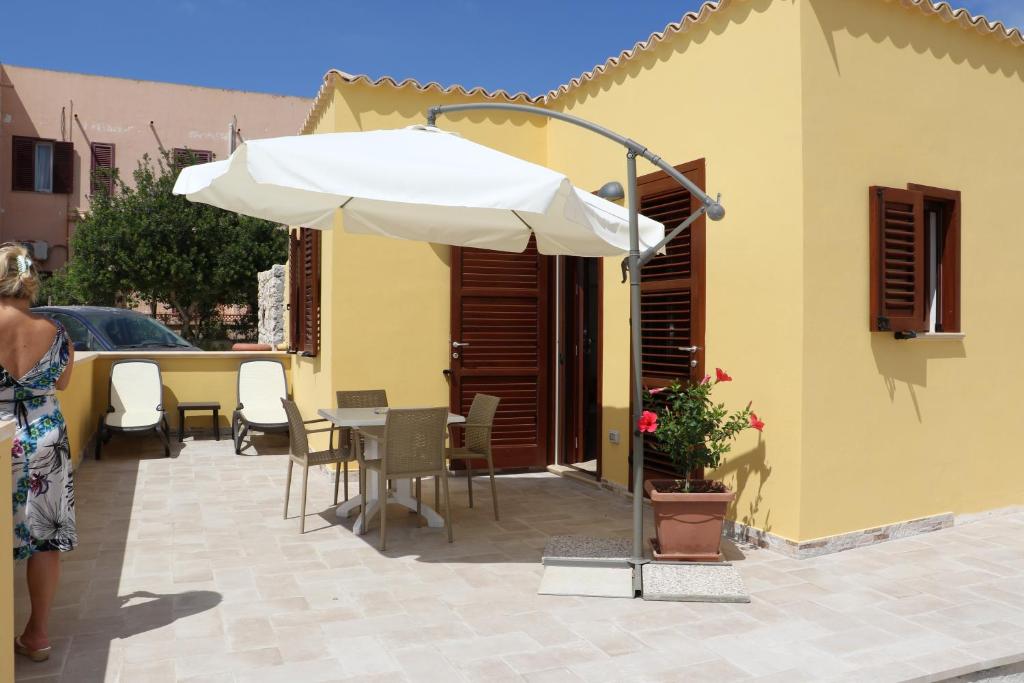兰佩杜萨Casette D'amore的庭院配有遮阳伞和桌椅。