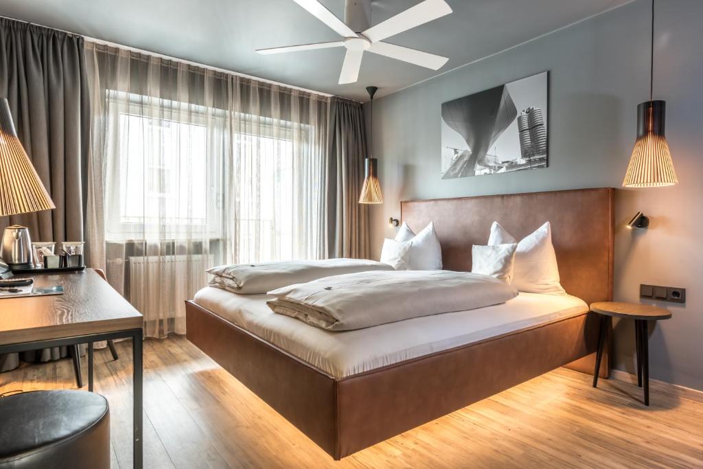 慕尼黑巴伐利亚精品酒店的一间卧室配有一张床、一张书桌和一个窗户。
