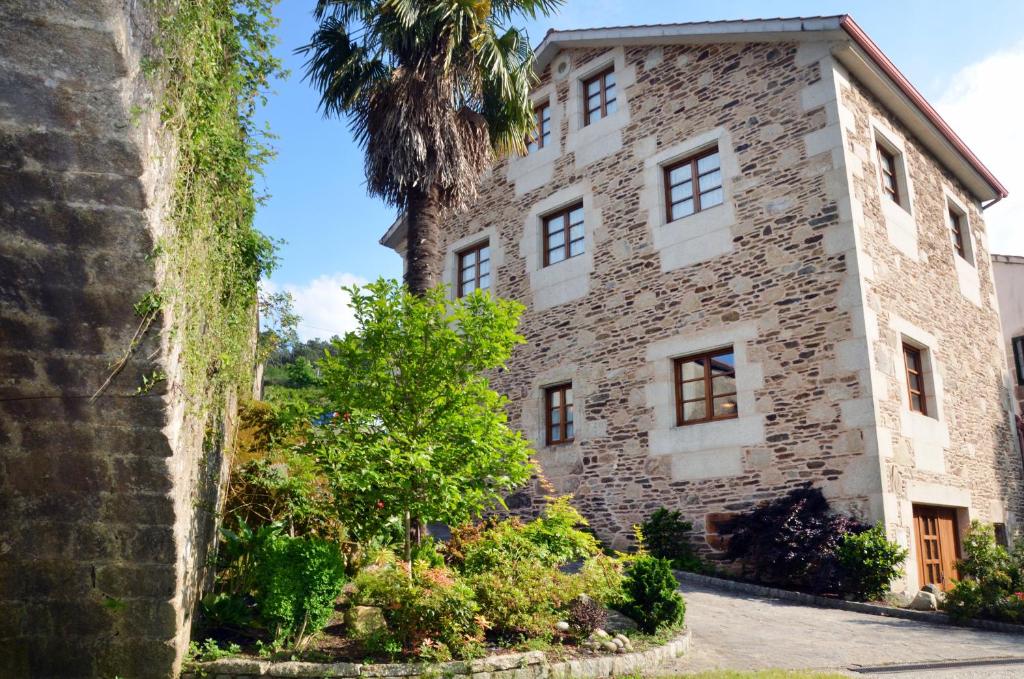 Gres卡皮亚旅馆的一座古老的石头建筑,有棕榈树