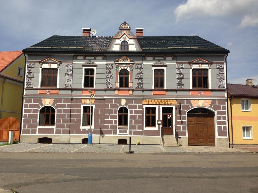 Mariánské RadčiceRestaurace U Kostela的一座带棕色门的大型砖砌建筑