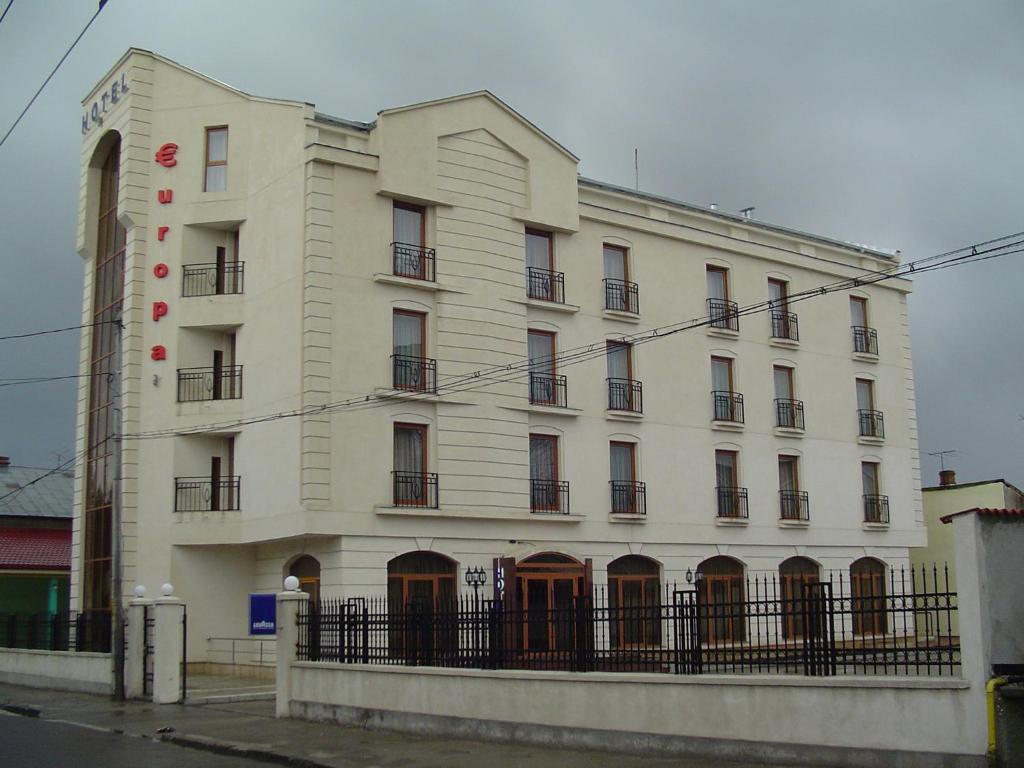 普洛耶什蒂欧洲酒店的前面有栅栏的白色建筑