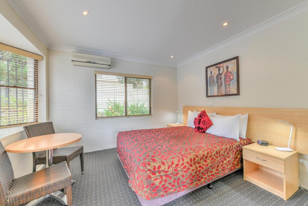 塔姆沃思格兰迪汽车旅馆的配有一张床、一张桌子和一张桌子的酒店客房