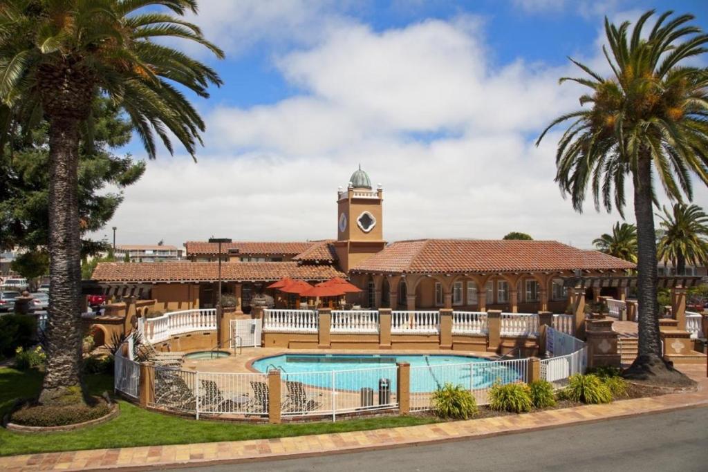 米尔布雷SFO El Rancho Inn SureStay Collection by Best Western的一个带游泳池和钟楼度假村