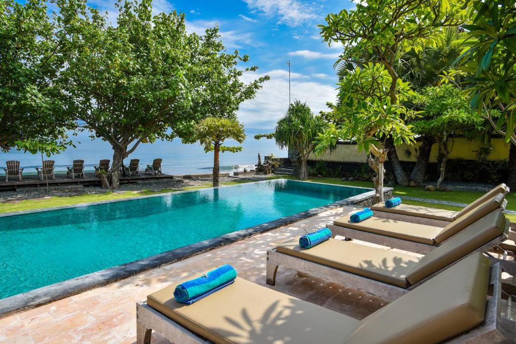 佩母德兰塞马迪别墅的毗邻度假酒店的带2张躺椅的游泳池