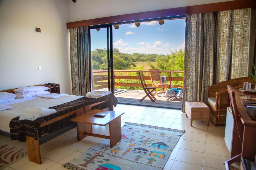 卢萨卡查米努卡小屋的一间卧室设有一张床和一个美景阳台