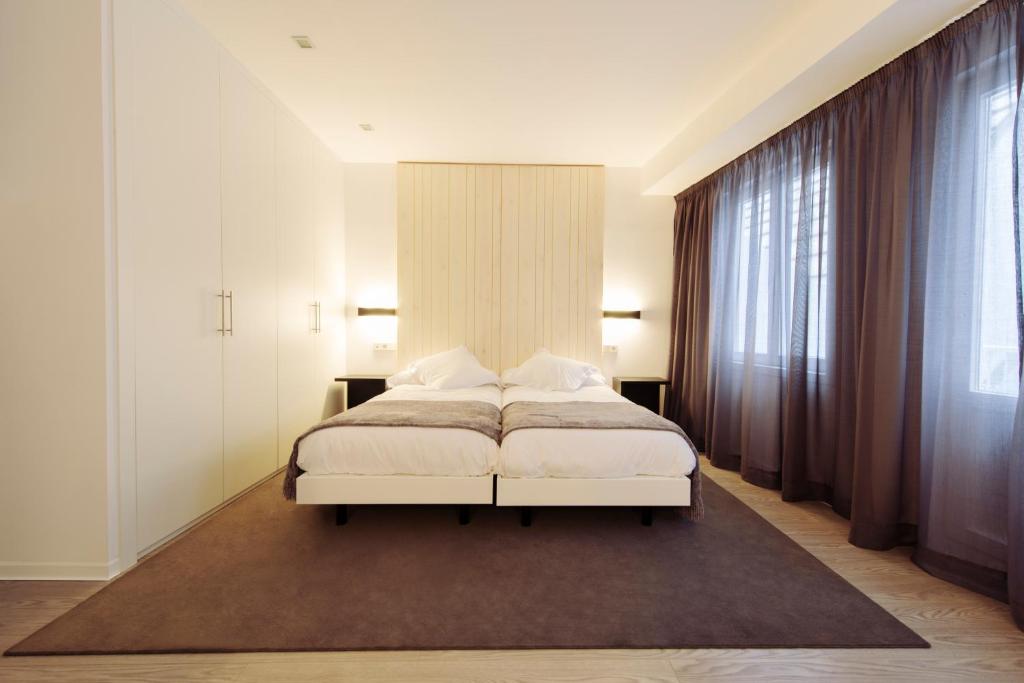 拉科鲁尼亚洛伊丝酒店的卧室设有白色的床和大窗户