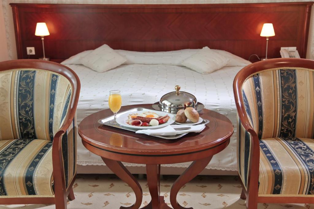 贝尔格莱德奥拉萨克酒店的床上的桌子和食物托盘