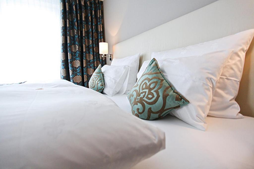葡萄酒之路上的诺伊施塔特Hotel Palatina "Hotel-Restaurant"的白色的床、白色枕头和窗户