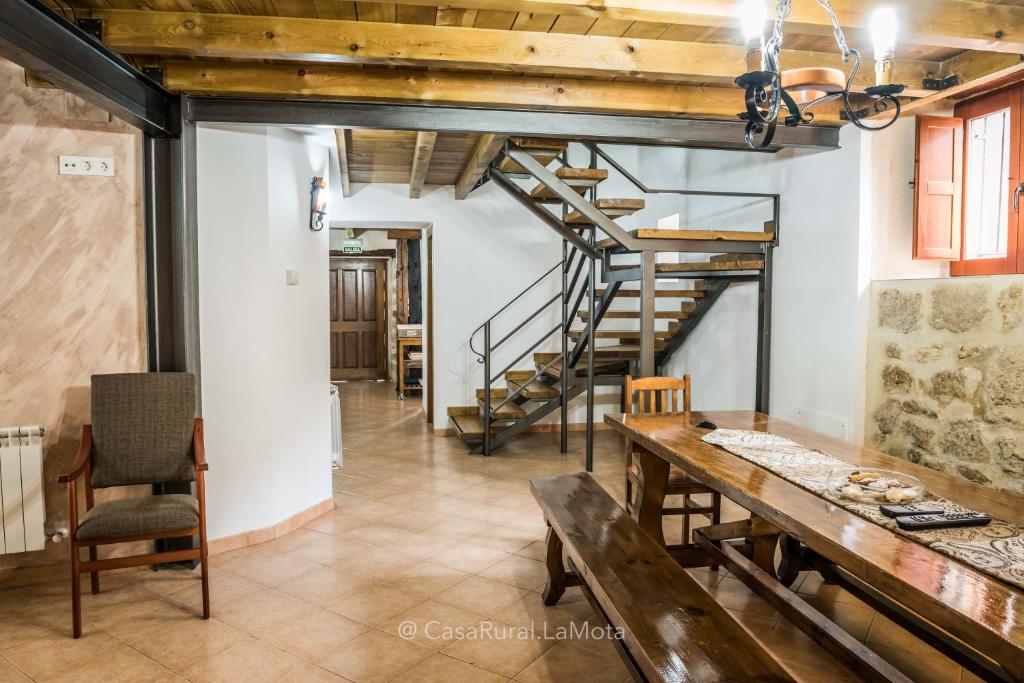 AstudilloCasa Rural "La Mota"的一间带木桌和楼梯的用餐室